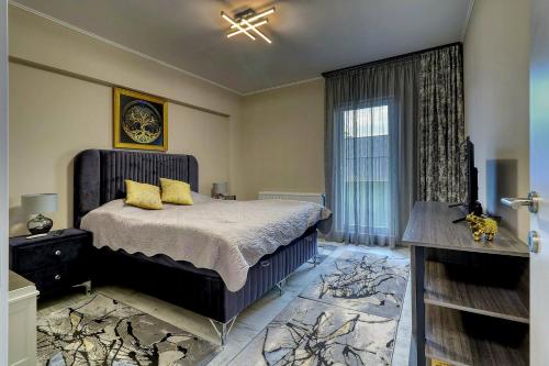 una camera da letto con un letto con cuscini gialli e una finestra di LUXURY Apartament a Bucarest