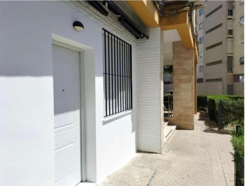 a white door on a building with a window at apartamento triana Arellano in Seville