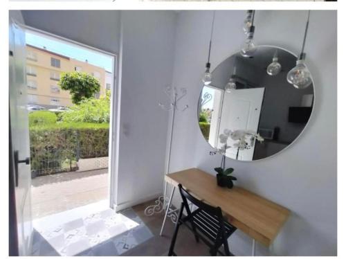 a mirror in a room with a table and a chair at apartamento triana Arellano in Seville