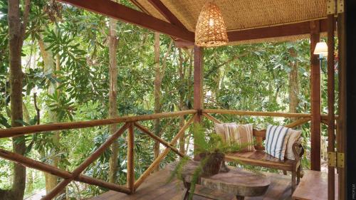 a screened in porch with a bench and a table at Pousada Tankamana in Itaipava