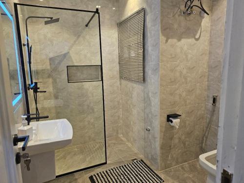 a bathroom with a shower and a sink at Urban View Lodge - Apt.5 Room 1 in Abuja