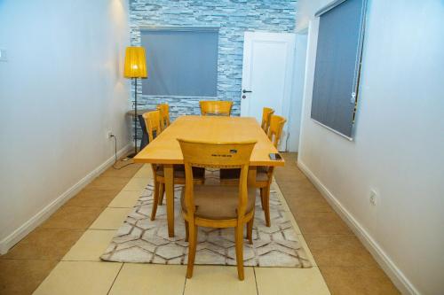 阿布賈的住宿－Urban View Lodge - Apt.5 Room 1，一间带木桌和椅子的用餐室