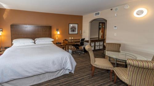 um quarto com uma cama, uma secretária e uma mesa em Lakeview Signature, Trademark Collection by Wyndham em Winnipeg