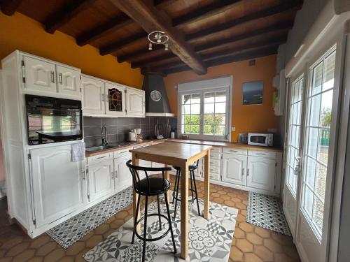 馬翁普拉日堡的住宿－Les Mésanges，厨房配有白色橱柜和木桌