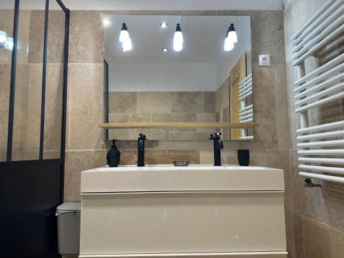 bagno con lavandino bianco e specchio di Maison au Pied de la Sainte Victoire a Puyloubier