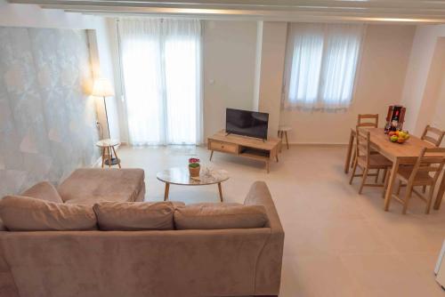 un soggiorno con un divano e una televisione di INFINITY SEASIDE APARTMENTS a Nea Kalikratia