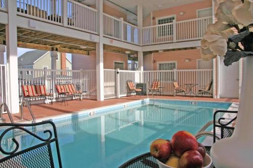 a pool with chairs and a bowl of fruit on a table at Monte Carlo Boardwalk / Oceanfront Ocean City in Ocean City