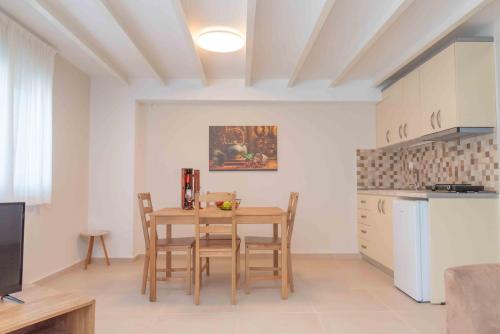 una cucina e una sala da pranzo con tavolo e sedie di INFINITY SEASIDE APARTMENTS a Nea Kalikratia