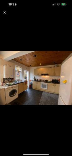 a kitchen with white cabinets and a white refrigerator at Best room- Near London luton Airport and close to Restaurants shops and Dunstable hospital in Luton