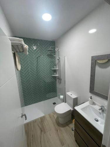 y baño con ducha, aseo y lavamanos. en Apartamento Vitelio en Carmona