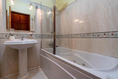 a bathroom with a sink and a bath tub and a sink at The Mountain View, By OP in São Vicente