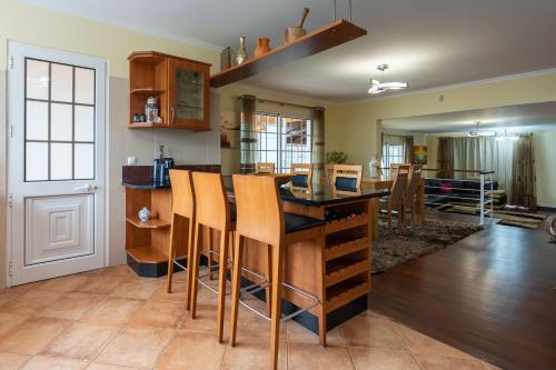 a kitchen with a bar with wooden stools at The Mountain View, By OP in São Vicente