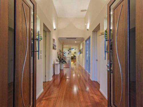 a hallway with wooden floors and doors in a house at Tranquility with views of the coast in Gold Coast