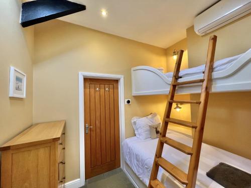 a room with a bunk bed and a ladder at Sheldon Barn in Bideford