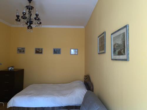 une chambre avec un lit et des tableaux au mur dans l'établissement Apartment at Rustaveli avenue, near opera, à Tbilissi