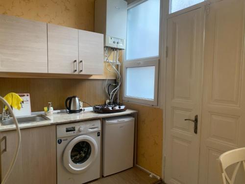 une cuisine avec un lave-linge à côté d'une porte dans l'établissement Apartment at Rustaveli avenue, near opera, à Tbilissi