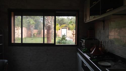 a kitchen with a window looking out at a yard at Villa isouktan in Sbiti