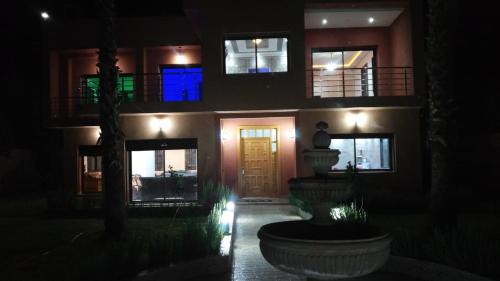 a house at night with a fountain in front of it at Villa isouktan in Sbiti