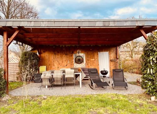 un patio con mesa y sillas frente a una cabaña en Ferienwohnung für die ganze Familie (Hunde willkommen!), en Zehdenick