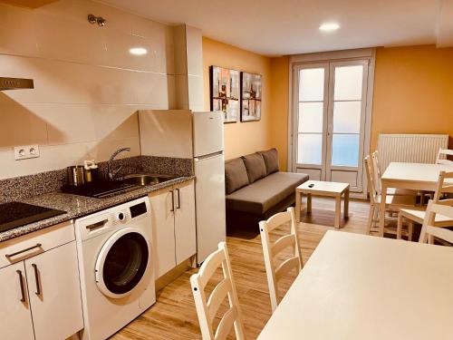 een keuken en een woonkamer met een bank en een tafel bij Apartamentos San Nicolás in Logroño