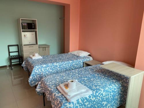Habitación de hotel con 2 camas y bandeja con toalla en Rooms MD y FS, en Huancayo
