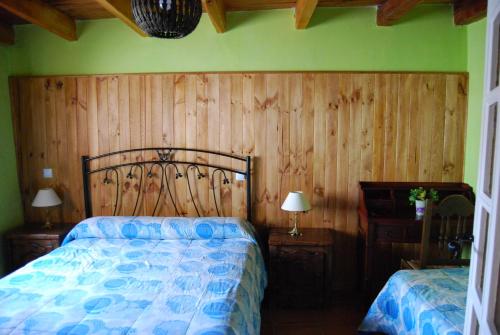 sypialnia z łóżkiem i drewnianą ścianą w obiekcie Arroyo Milano Casa Rural w mieście Maello