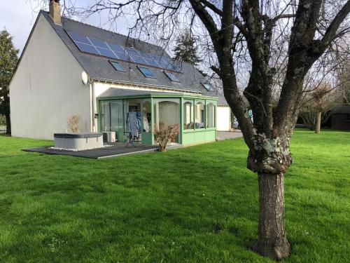 uma casa com uma árvore na relva em Le Moulin de montinault em Mulsanne