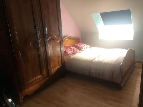 um quarto com uma cama e um armário de madeira em Le Moulin de montinault em Mulsanne