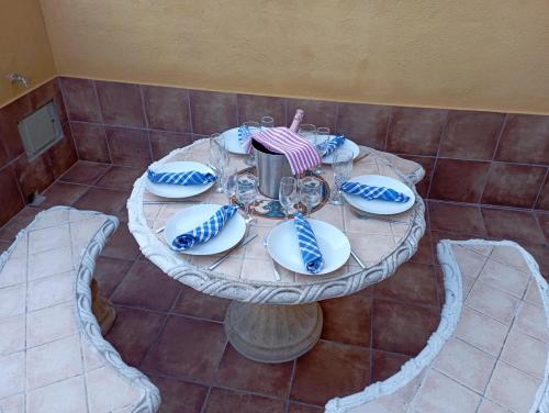 a round table with blue and white plates on it at PEP'S Family House in Empuriabrava