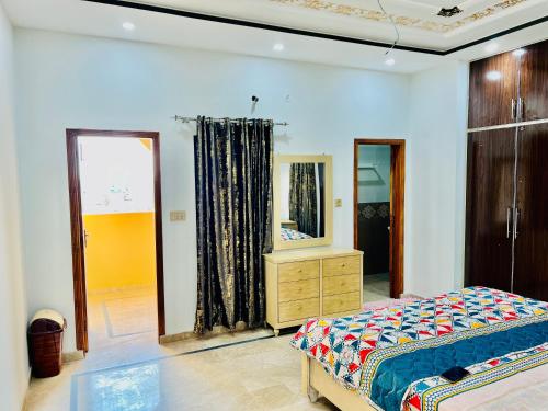 1 dormitorio con cama, tocador y espejo en Golden Plaza, en Gujrānwāla