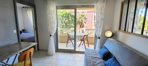 - un salon avec un canapé et une table sur un balcon dans l'établissement Love nest with balcony close to the sea, à Fréjus