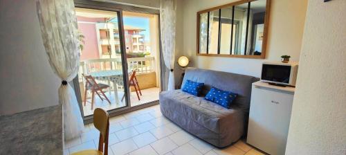 Il comprend un salon avec un canapé, une télévision et un balcon. dans l'établissement Love nest with balcony close to the sea, à Fréjus