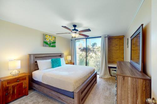 - une chambre avec un lit et un ventilateur de plafond dans l'établissement Turtle Bay Resort 166, à Kahuku