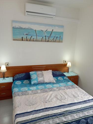a bedroom with a bed and a painting on the wall at PEP'S Family House in Empuriabrava