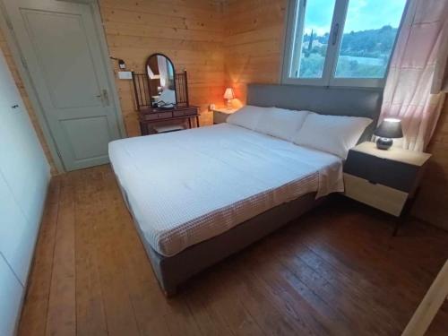 - une chambre avec un grand lit blanc et une fenêtre dans l'établissement ViladeMadeira, Crete, à Amnátos
