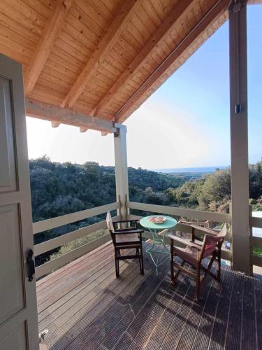 - une terrasse couverte avec une table et des chaises offrant une vue dans l'établissement ViladeMadeira, Crete, à Amnátos