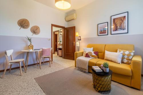 a living room with a yellow couch and a table at Sweet Home Graziella vicino stazione Bologna per 6 persone in Bologna