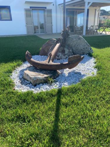 a fire pit with two boats in the grass at Residenza “La Vecchia Ancora” in Castelsardo