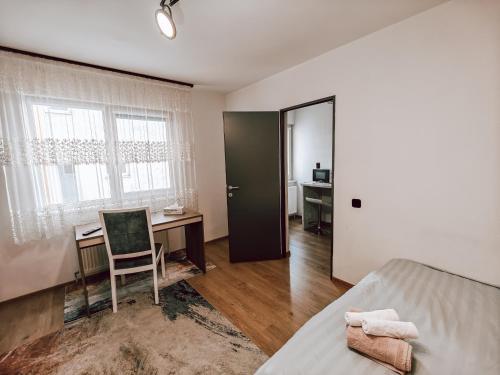 een slaapkamer met een bed, een bureau en een stoel bij Charming City Hideout in Cluj-Napoca