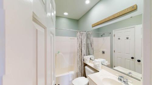 een badkamer met een wastafel, een toilet en een spiegel bij Litchfield Beach Retreats 2BR Scenic Balcony Views in Pawleys Island