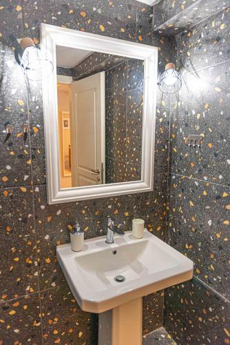 a bathroom with a sink and a mirror at INFINITY SEASIDE APARTMENTS in Nea Kallikrateia
