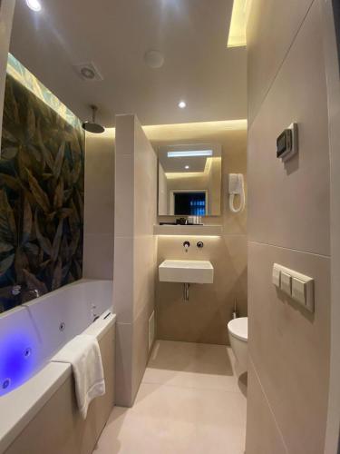 a bathroom with a tub and a sink and a toilet at Alp Hotel in Amsterdam