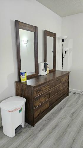 a room with a dresser with a mirror and a microwave at Bright and Cozy Room with Free Parking in Edmonton