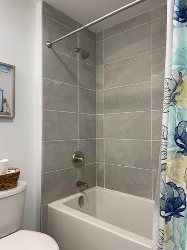 een badkamer met een douche, een bad en een toilet bij Deluxe Place on Kawartha Lakes in Fenelon Falls