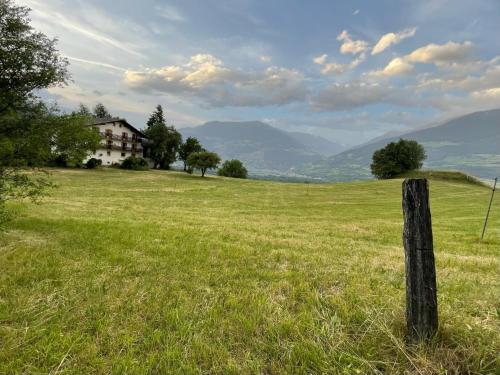 a field with a fence and a house on a hill at Plasur - Apartement Bella Vista in Montechiaro