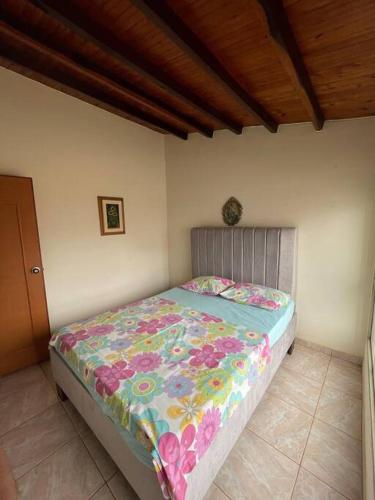 una camera da letto con un letto con un piumone colorato di Villa Concha a Villanueva