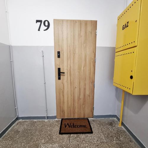 a wooden door with a welcome sign in front of it at Na Szczycie in Chełm