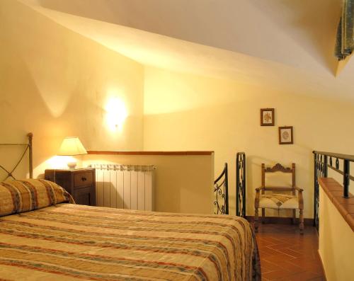 um quarto com uma cama e uma cadeira em Agriturismo Poggio de Papi em Cantagrillo