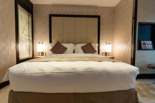- une chambre avec un grand lit et 2 lampes dans l'établissement غرف بخدمات فندقية, à Riyad