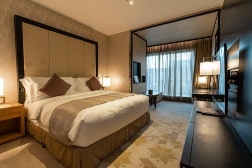 - une chambre avec un grand lit et une grande fenêtre dans l'établissement غرف بخدمات فندقية, à Riyad